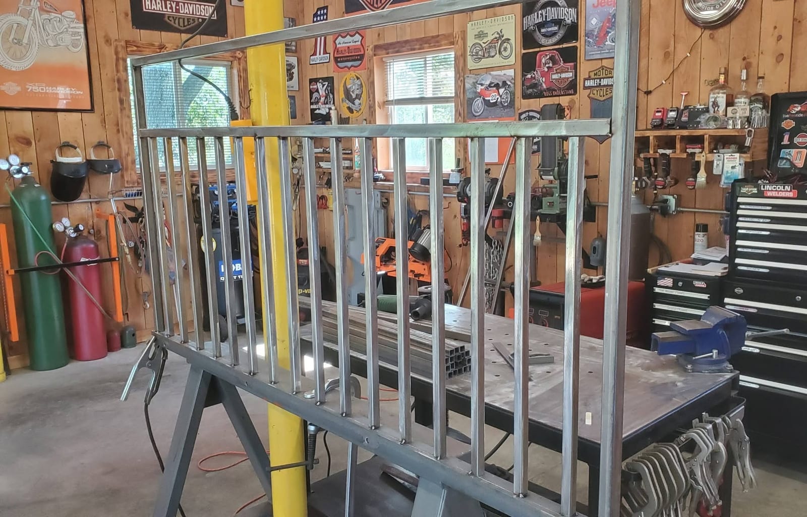 A steel railing panel with welded balusters clamped on the welding table in the Robinson Welding shop