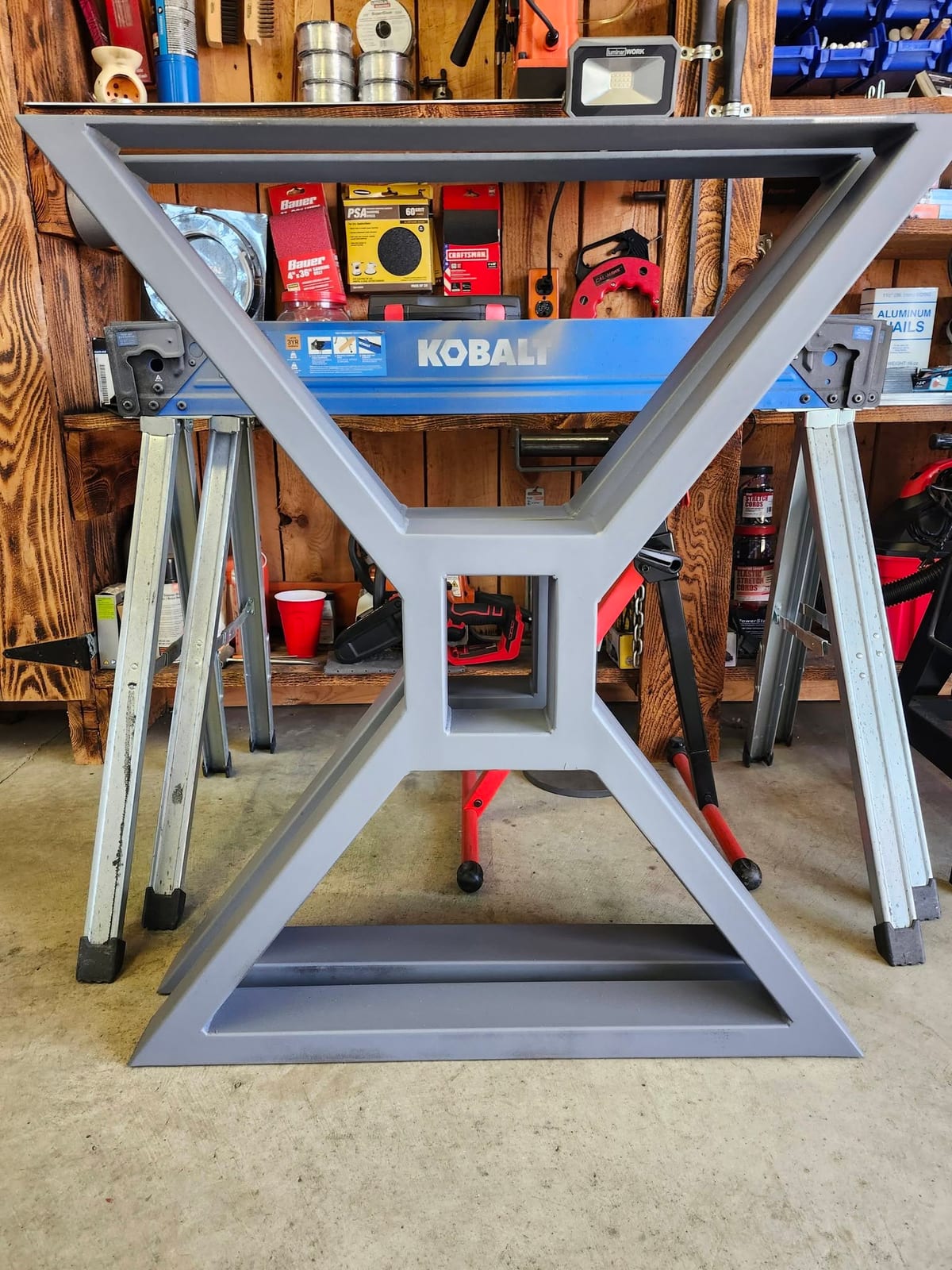 A finished gray painted steel table base fabricated in the Robinson Welding shop